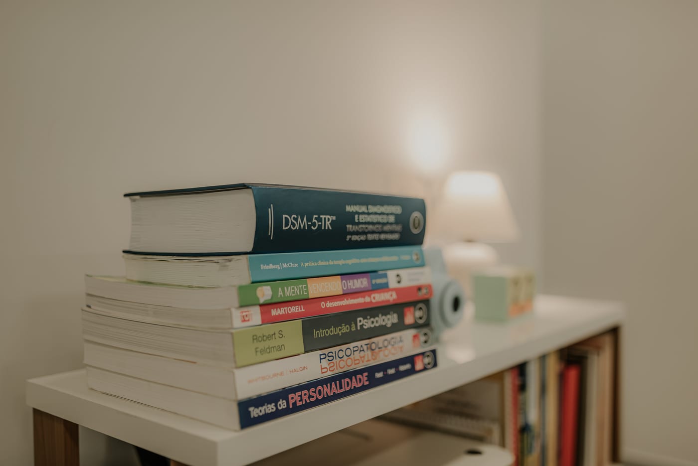 Livros de psicologia e manuais de referência sobre a bancada do consultório